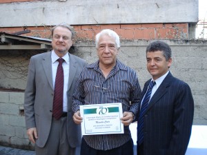 Nos 70 anos da AMCE, o comentarista Maurílio Costa foi um dos homenageados e recebeu o diploma comemorativo das mãos do prefeito de BH, Márcio Lacerda e do presidente da entidade, Carlos Cruz